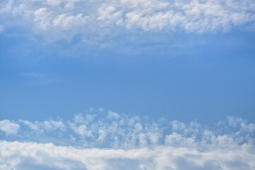 Two horizontal stripes of clouds, between which there is a clear blue space of the sky
