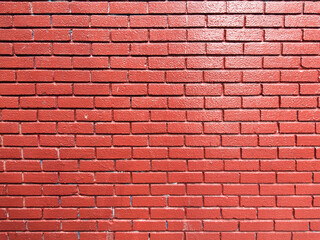Brick wall texture painted with red saturated color. Masonry craft and industry. Abstract background