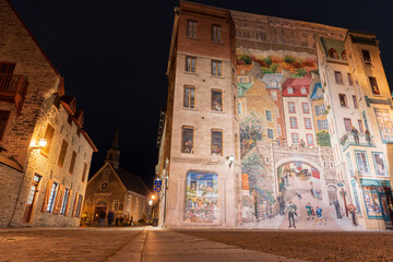 Fototapeta premium Quebec, Canada - October 18 2021 : Fresco Wall Art in the Quebec City Old Town in autumn night. Mural of Quebecers.