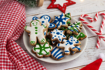 Homemade gingerbread cookies painted with colorful glaze surrounded by New Year's accessories. Christmas Baby Cookies