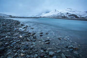 The blue water of the Kongakut River flows through the Arctic National Wildlife Refuge after the first snow of winter, Alaska. 