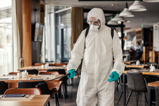 Fight against COVID19. A person in a white protective suit with protection checking a restaurant situation. Coronavirus life, new normal, corona rules