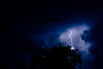 Night sky with lightning in a thunderstorm. Dramatic weather.