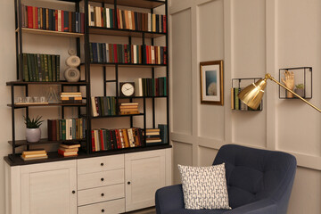 Cozy home library interior with collection of different books on shelves and comfortable place for reading