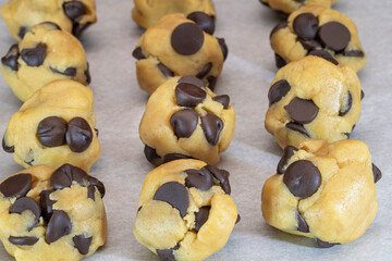 balls of chocolate chip cookie dough with extra large chips ready for the oven