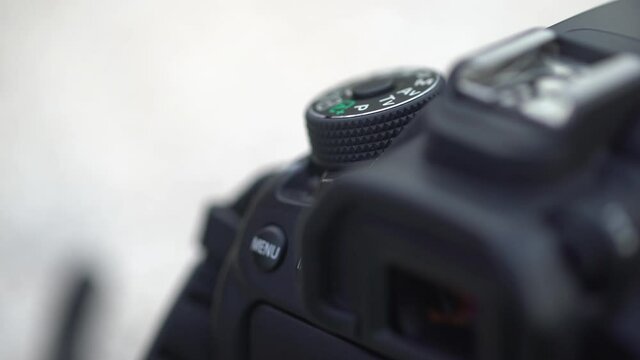 Digital dslr camera on off buttons closeup. View in low focus. Hand push the on button.