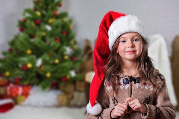 Happy small girl standing indoors at Christmas decor