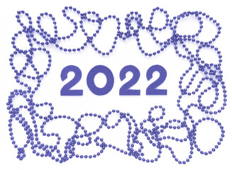 Violet felt numbers 2022 and beads around in trendy very peri Pantone color of the year 2022 on white background. Flat lay for Valentine's Day or New Year.