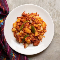 Potatoes with chorizo on a gray background.  Mexican food