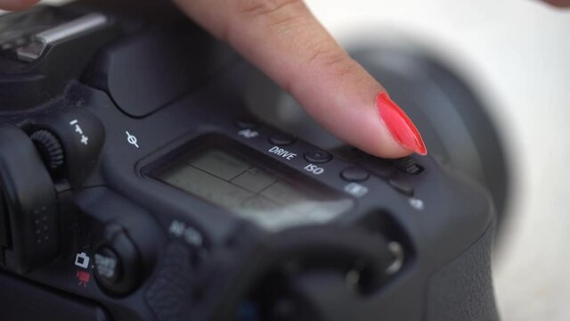 Digital dslr camera buttons closeup. View in low focus. Hand push the on button.