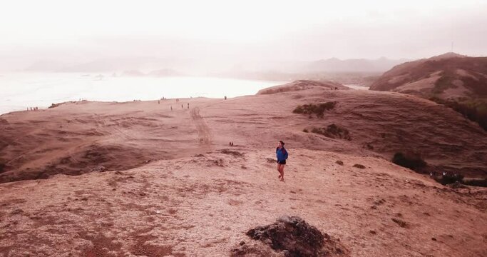 Female hiker walking alone on Padar island hill