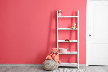 Shelf unit with toys near color wall in room