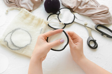 Woman stitching reusable cotton pad on white background © Pixel-Shot