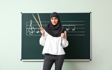 Muslim music teacher giving lesson at school