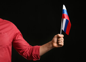 Male hand with flag of Russia on dark background