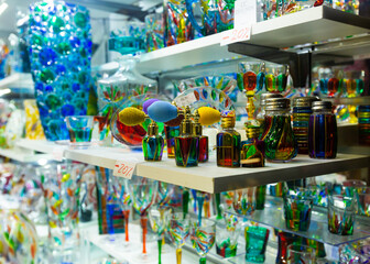 Naklejka premium Original Murano art glass figures and glassware on display in Venetian souvenir shop ..