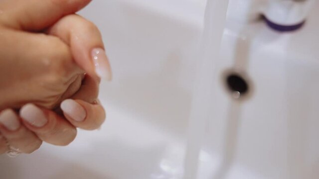 woman washing her hands in the bathroom, hands close-up