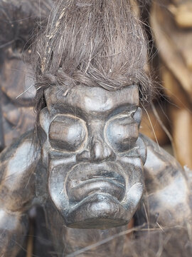 Russia, Sochi 06.06.2021. The scary face of an ethnic figure made of dark wood. Decorative figure in The African style. Closeup photo