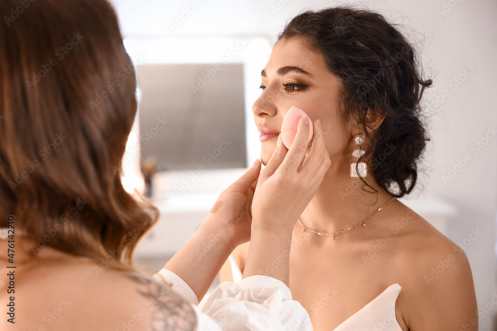 Wall mural Makeup artist working with beautiful model in beauty salon