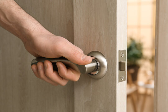 Man opening door at home, closeup