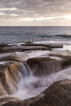 Vertil view of rocky cliffs near the sea at daylight