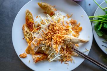 Steamed rolled rice pancake Vietnamese food, made from rice flour filled with meat, mushrooms, served with spring rolls, chili fish sauce and herbs, a nutritious breakfast favorite