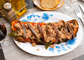 Appetizing Spanish snack Torrada de atun, made from tuna toast, bell pepper, onion and a small...
