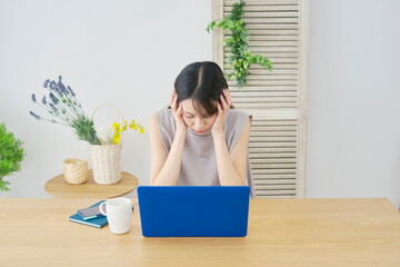 女性　パソコン　リビング　頭を抱える