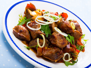 Portion of stewed beef with mushrooms, bell pepper, onion garnished with parsley