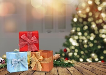 Wooden tabletop with gift Christmas decoration and blurred modern room as background.