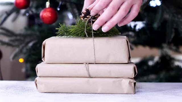 zero waste christmas gift decorated pine cone and fir branch with craft paper, no plastic holidays with lights garland christmas tree at home.