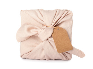 Gift wrapped in fabric with tag on white background