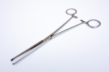 Medical clamp tweezers for operations on white isolate. Surgical instrument on a white background.