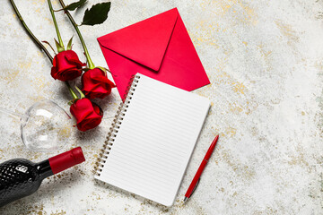 Empty notebook with wine, envelope and rose flowers on grunge background