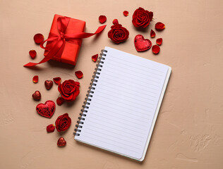Romantic composition with empty notebook and gift on color background