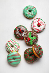 Different tasty Christmas donuts on white background