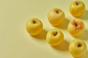 Naklejka na ściany i meble Yellow apple on pastel yellow background. Healthy apples.