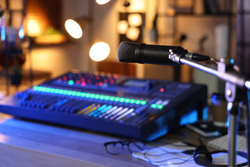 Fototapeta na wymiar Microphone near table with professional mixing console in radio studio