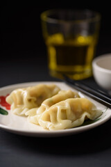 Wonton stuffed, gyoza or dumplings, Asian cultural food on black background