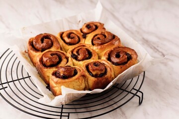 Beautiful Fresh Baked Homemade Cinnamon Rolls Close Up on White Table. Fragrant Homemade Cakes, Cinnabon with Raisin.