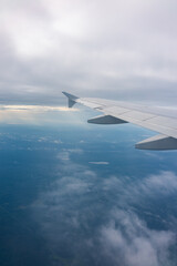 View from the airplane window at a beautiful blue sunrise and the airplane wing in clear sky.