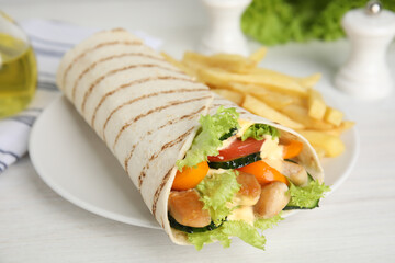 Delicious shawarma with chicken meat and fresh vegetables served on white wooden table, closeup