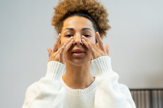Young woman touching her healthy skin. Woman smiling african american woman. Youth and skin care concept