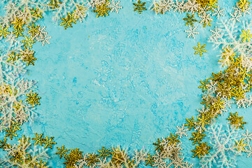 frame of white and gold snowflakes on a blue background