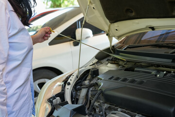 Vehicle safety concept, Woman's hand checking car engine before driving. Car Maintenance engine oil level checking.