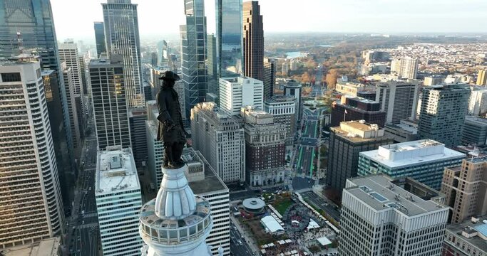 Aerial orbit reveal Philadelphia skyline. Silhouette of William Penn statue above City Hall. Benjamin Franklin Parkway, downtown urban financial district in USA.