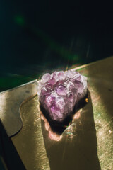 sparkling purple amethyst crystal geode rock on brass gold table - obrazy, fototapety, plakaty