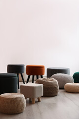 Different stylish poufs and ottomans in room, space for text