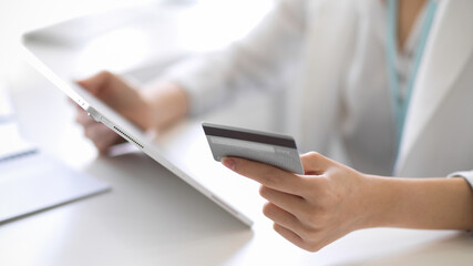 Cropped image of a businesswoman holding credit card and digital tablet