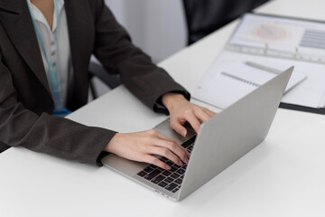 Cropped image of a business woman typing on laptop computer